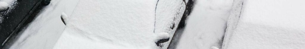 parked cars covered with snow.